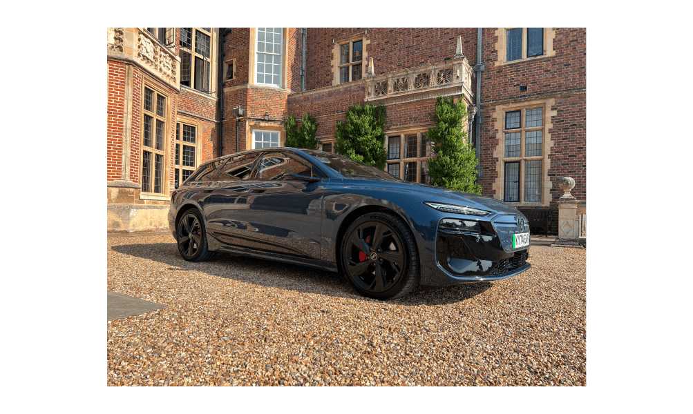 A picture of the Audi A6 Avant e-tron parked outside of a stately home.